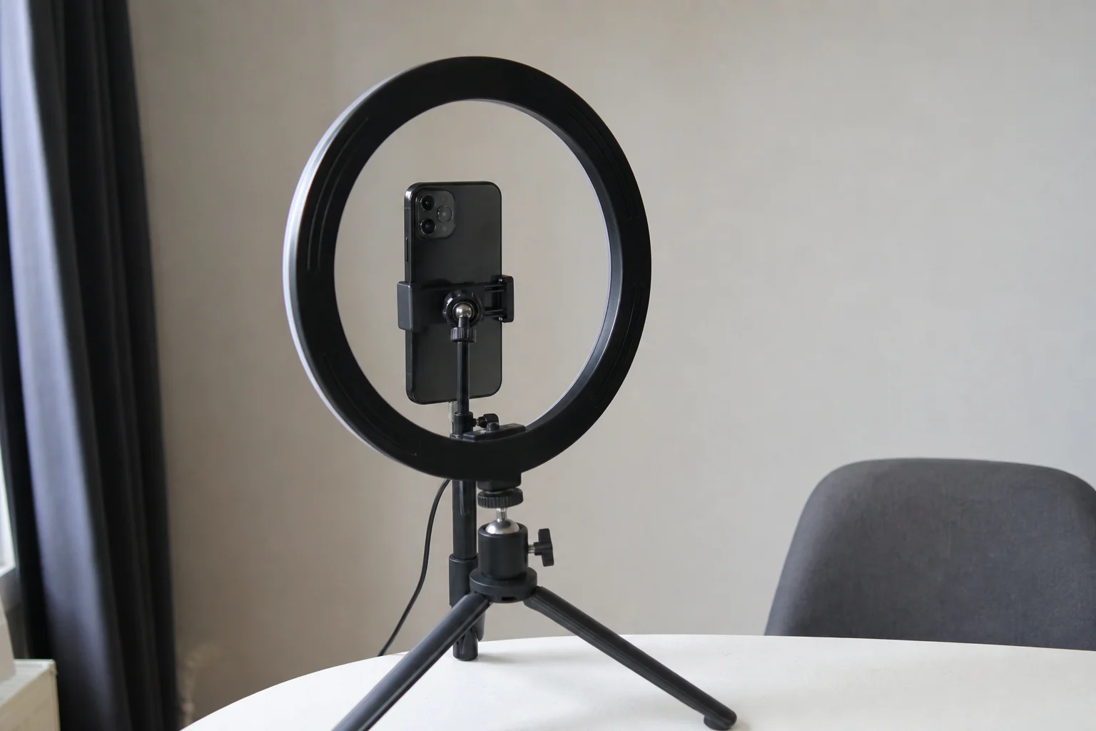Smartphone på bordsstativ med ringlampa, uppställd inför inspelning inför AI-filter och selfies